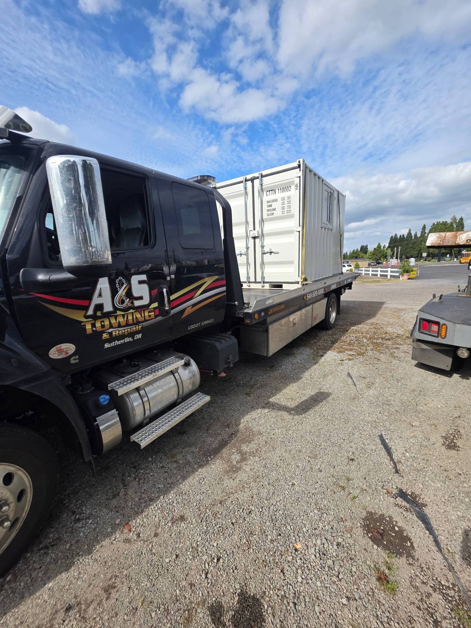 Flatbed hauling shipping container